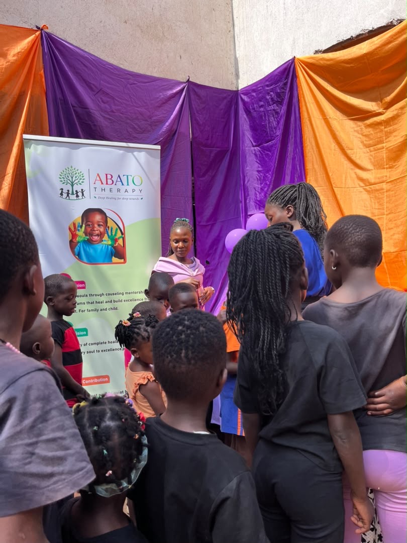 Children gathered around ABATO's support banner